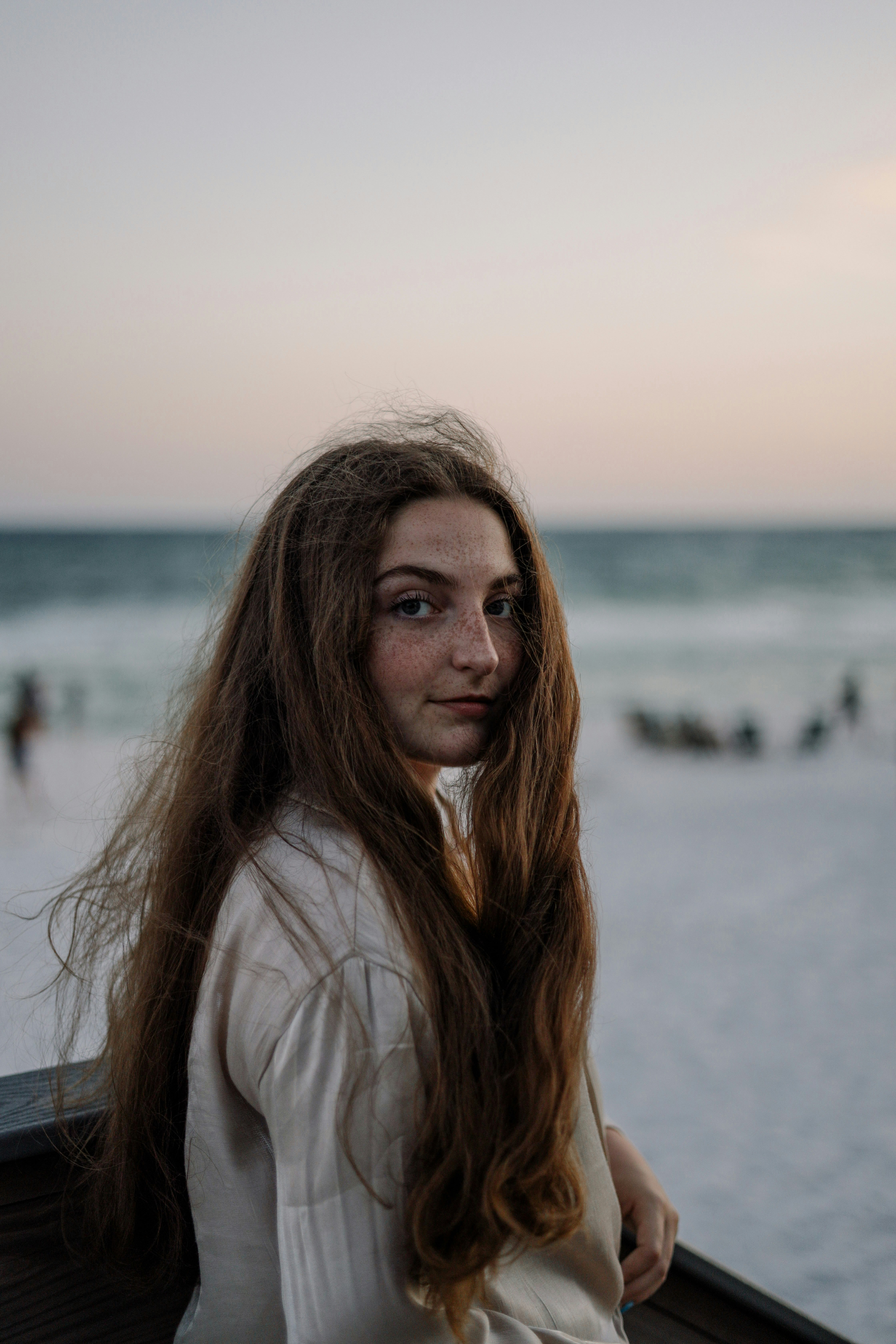 woman in white long sleeve shirt standing on beach during daytime